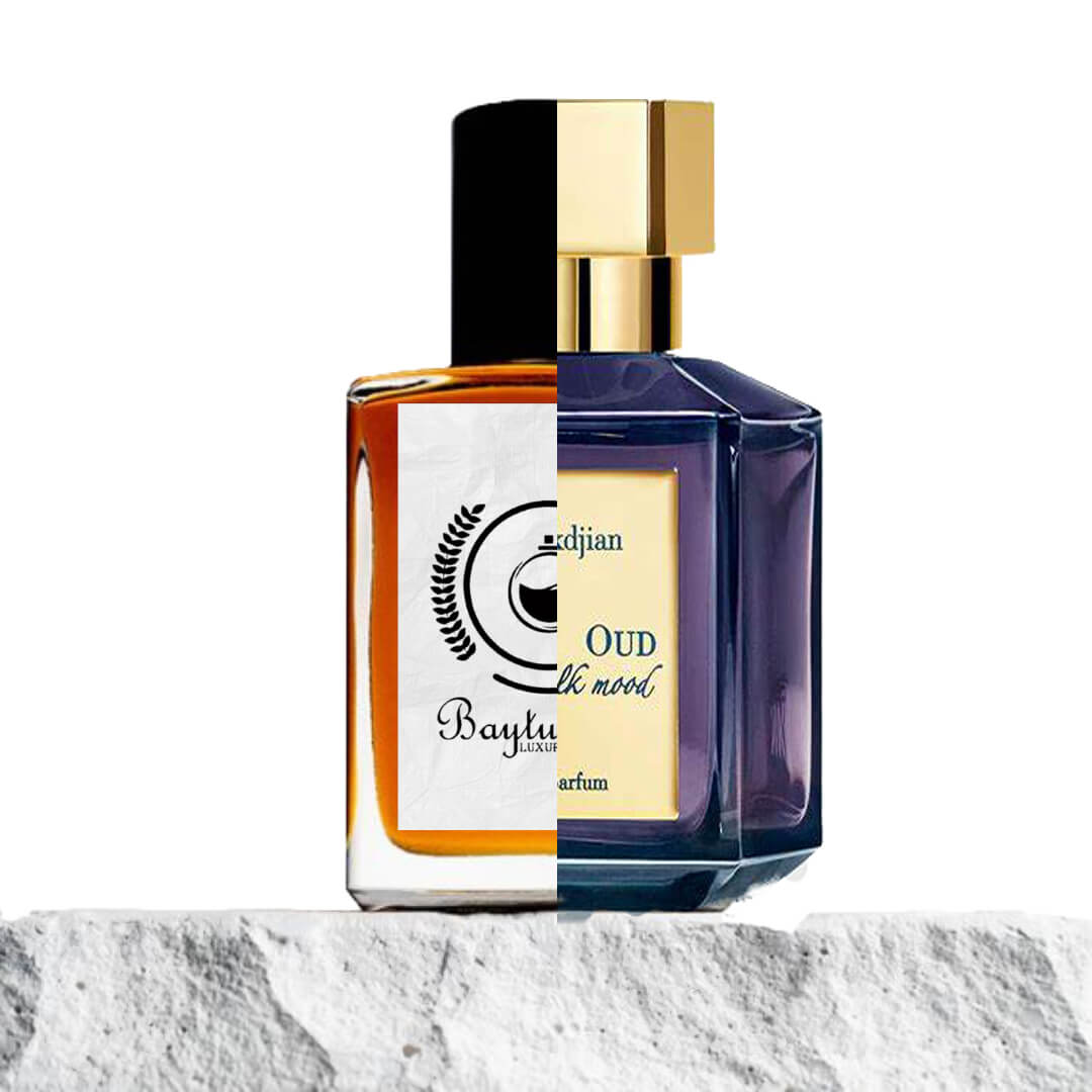 "Two perfume bottles are elegantly placed on a textured rock, set against a natural backdrop."
"On the left, an amber-colored bottle represents the Baytulkenz inspired version of "Oud Silk Mood Maison Francis Kurkdjian."
"On the right, a black and cream-colored bottle with a label reads "Oud Silk Mood Maison Francis Kurkdjian," showcasing its luxurious design."
