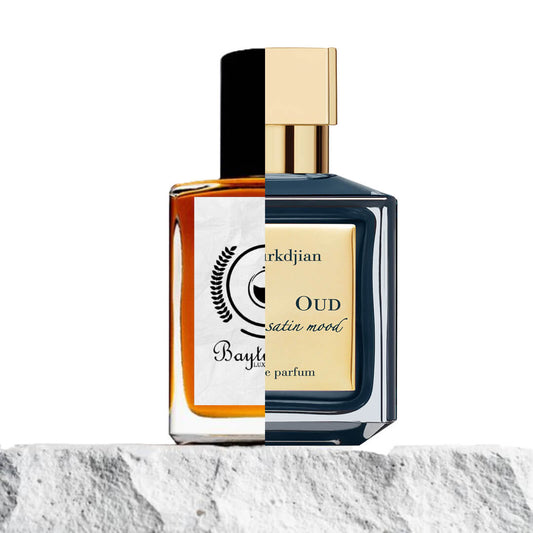 "Two perfume bottles are elegantly placed on a textured rock, set against a natural backdrop."
"On the left, an amber-colored bottle represents the Baytulkenz inspired version of "Oud Mood Satin Maison Francis Kurkdjian.""
"On the right, a black and cream-colored bottle with a label reads "Oud Mood Satin Maison Francis Kurkdjian," exuding sophistication."
"The amber bottle contrasts with the dark and cream tones of the original, both showcasing luxurious design elements."